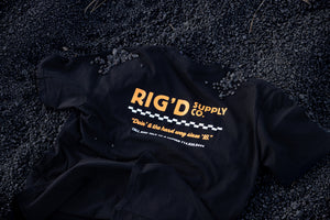 Black jacket with 'Rig'd Supply Co.' logo on a dark textured surface
