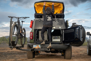 Woman stepping on open RambleSwing to access roof of Ford Bronco